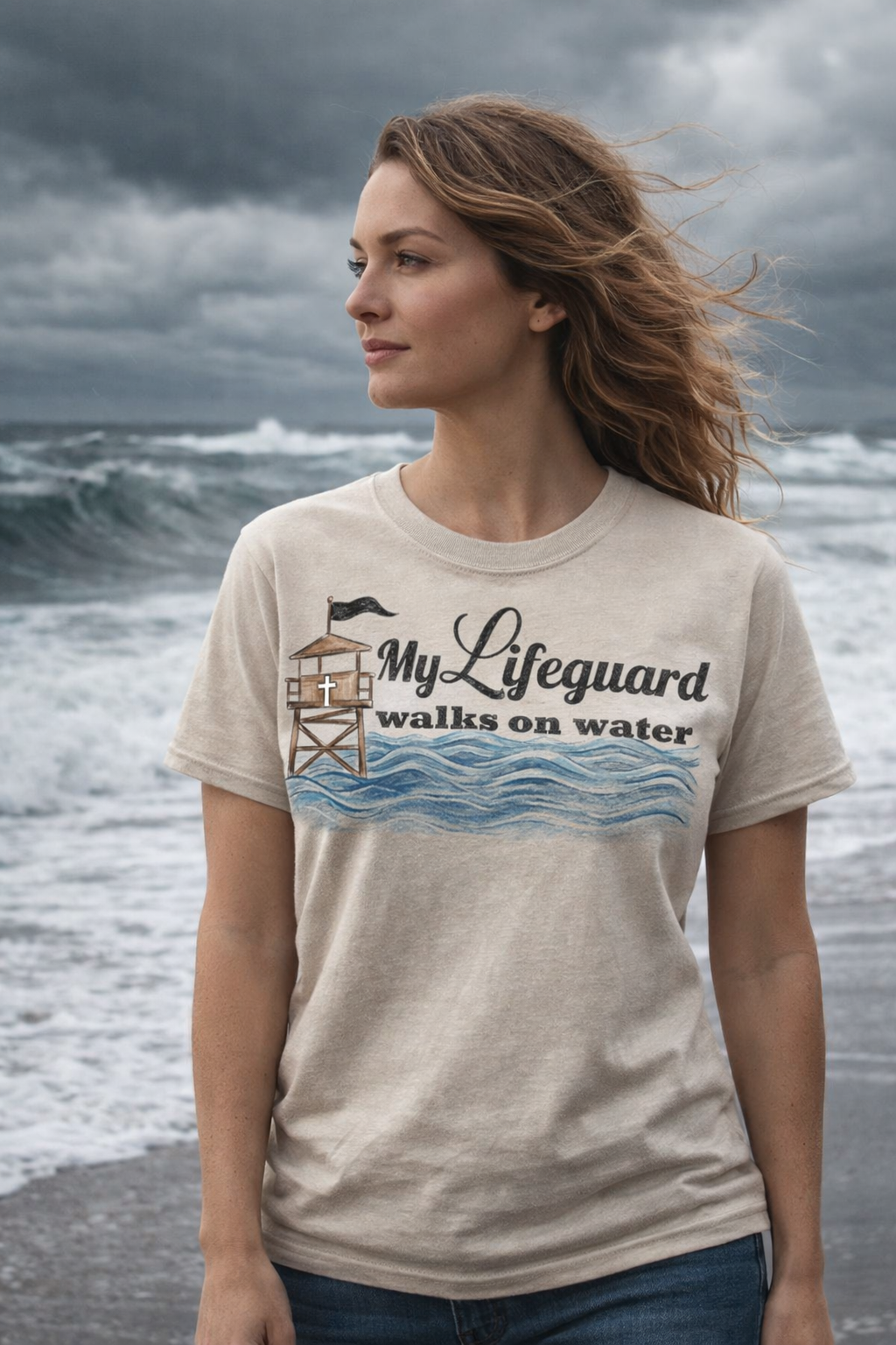 Woman wearing “My Lifeguard Walks on Water” Christian t-shirt standing on a stormy beach, representing faith in Jesus who walked on water. 