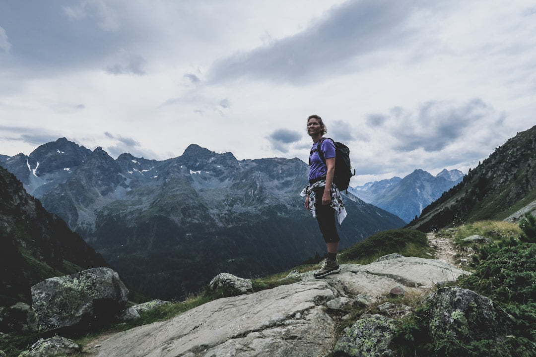 A man standing on a mountain cliff overlooking a valley, representing the spiritual journey of discipleship