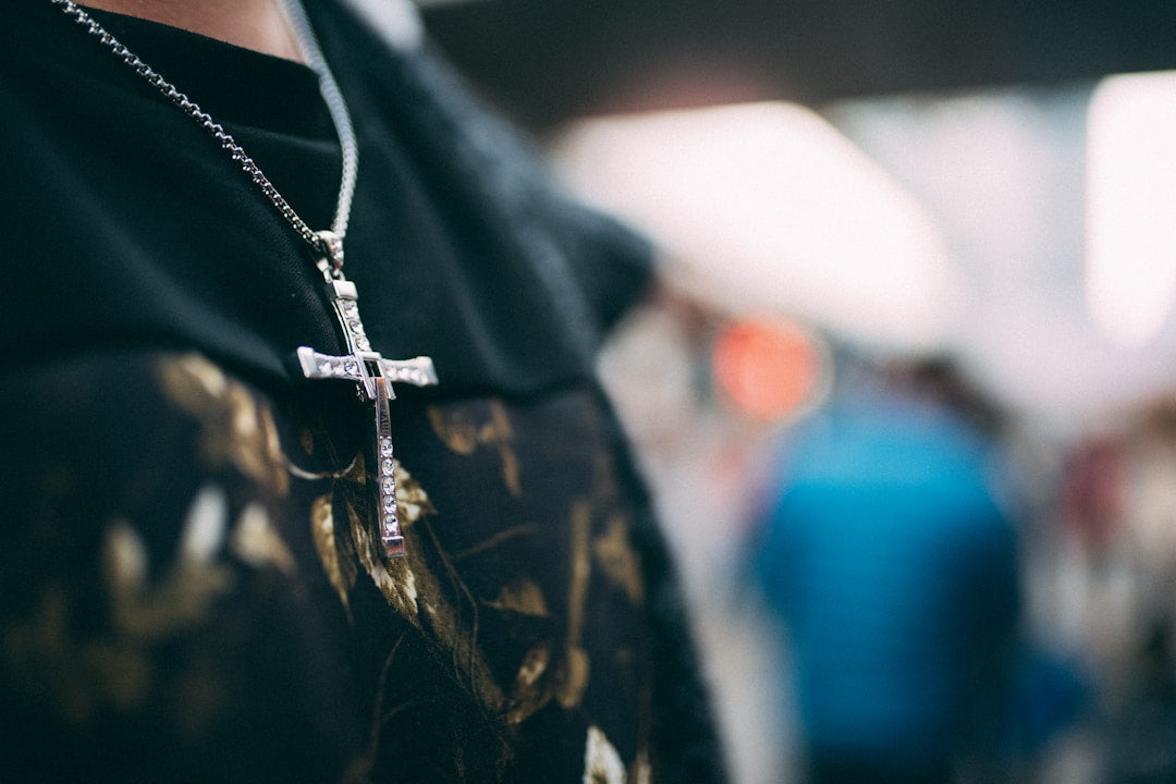 Christian man wearing a black shirt and cross necklace, representing bold faith and biblical masculinity