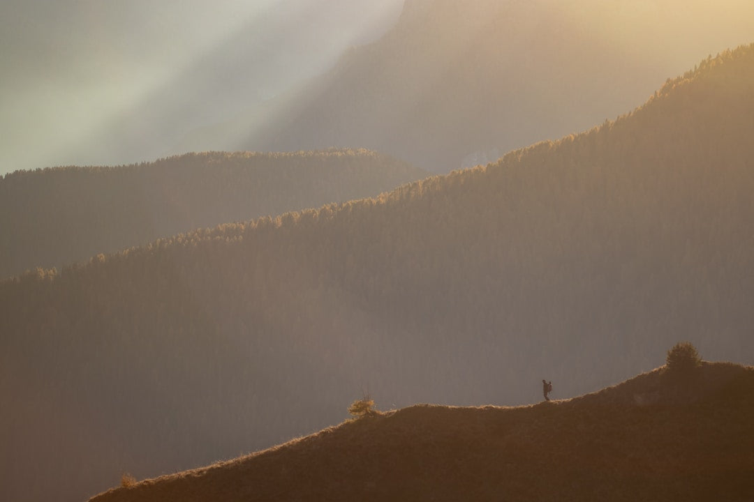 Strong man hiking mountain sunset