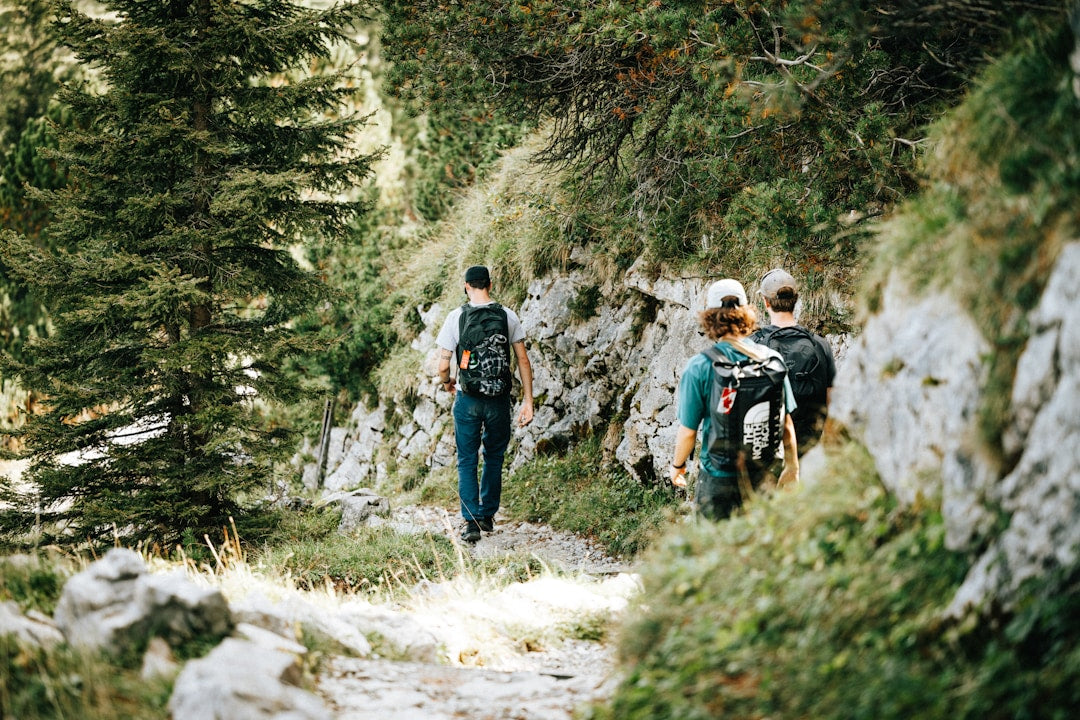 Three men hiking on a mountain trail, representing shoulder-to-shoulder discipleship